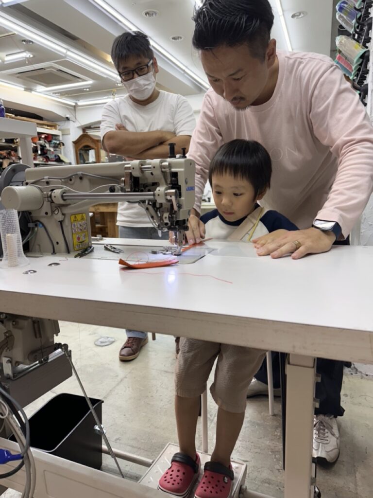子どもが本格的な腕ミシンでランドセルを製作している様子