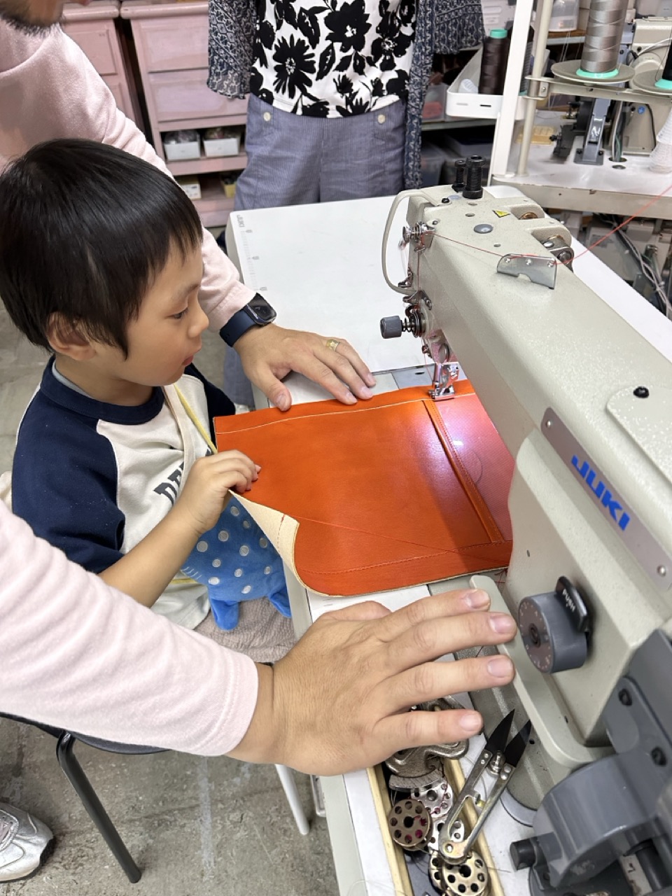 子どもがHEXIONの工業用ミシンでランドセルを製作している様子