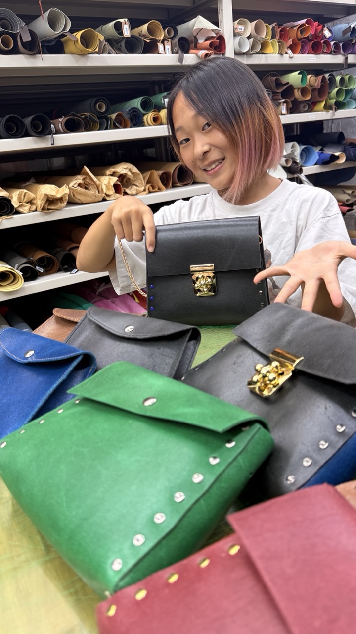 色とりどりの革のバッグやポーチを並べ、自分の作品を紹介するしゃっくりんぐりんごの作り手